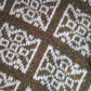 Brown flecked sweater with white geometric pattern